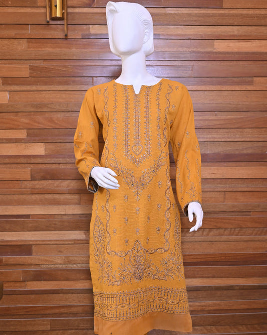 Mustard yellow embroidered kurta on a wooden background